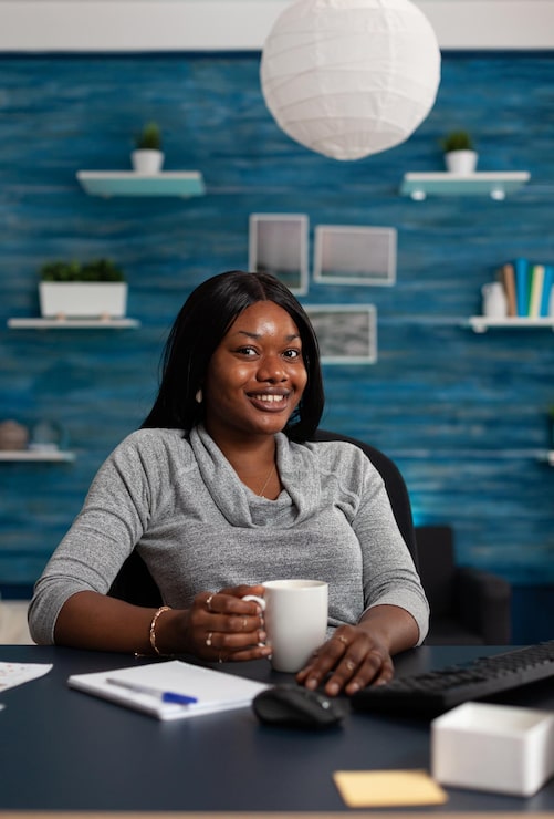portrait-woman-smiling-sitting-desk-with-computer-working-from-home-business-project-young-adult-looking-camera-using-monitor-with-keyboard-remote-work_482257-33612 (1)
